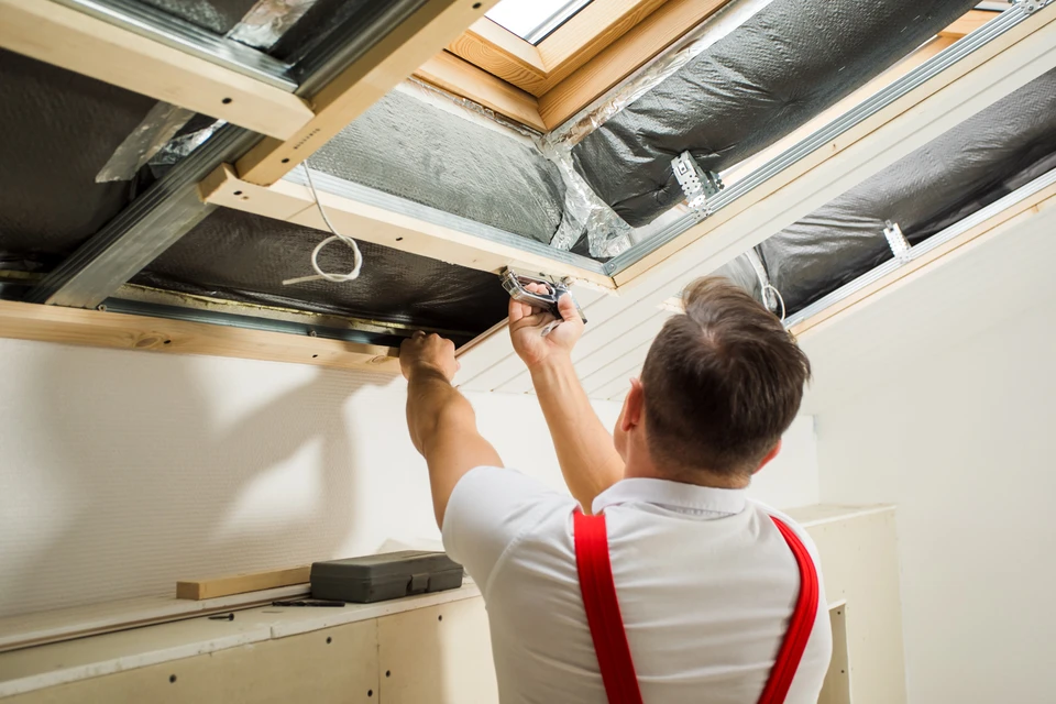 Vue arrière du maître qui attache le boisseau sous le toit