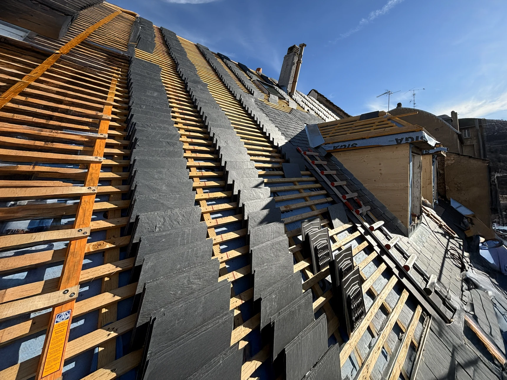 Scène extérieure montrant une toiture résidentielle sous ciel dégagé
