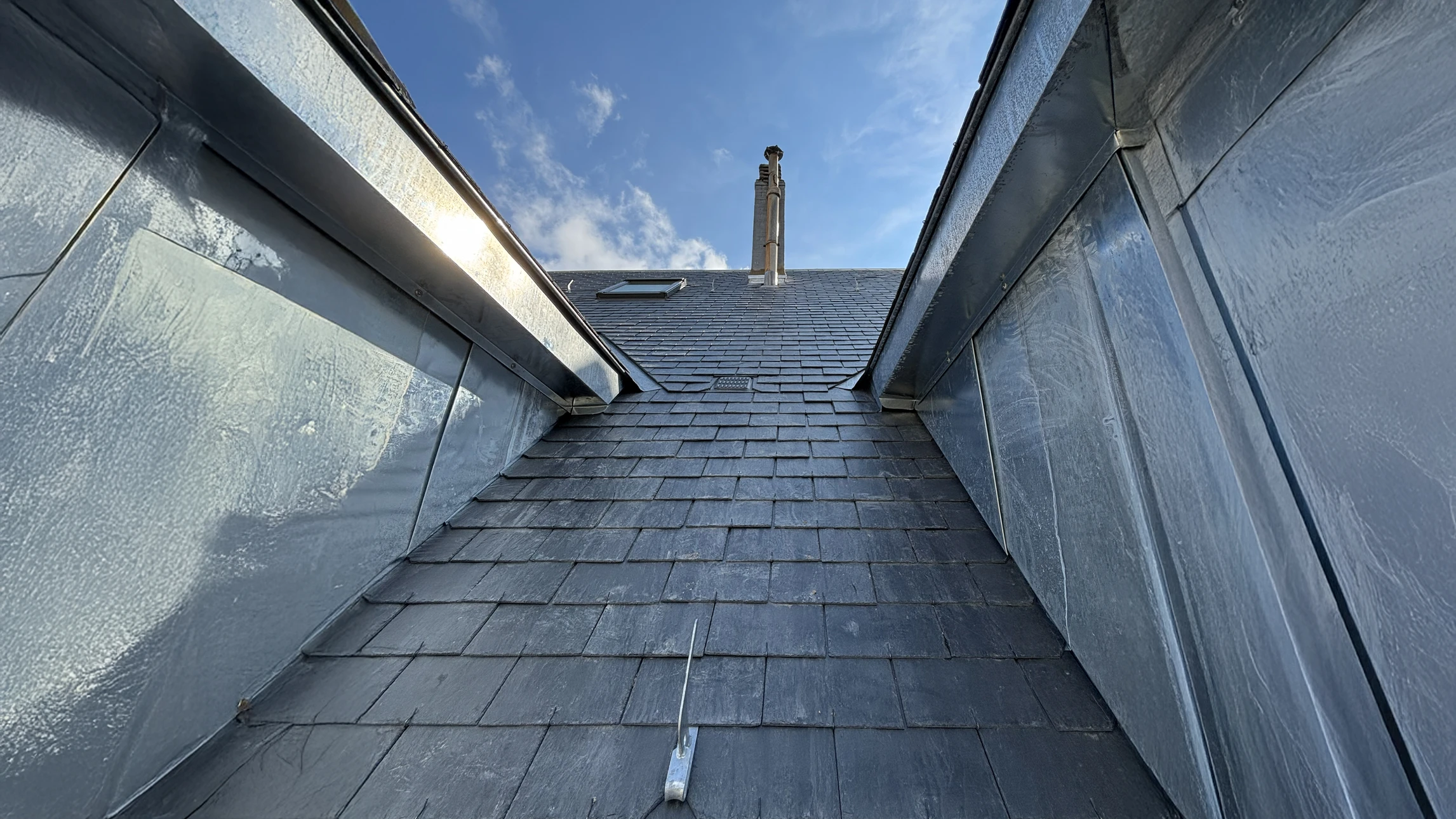 Maison contemporaine avec façade en bardeaux bleus et soubassement en pierre naturelle