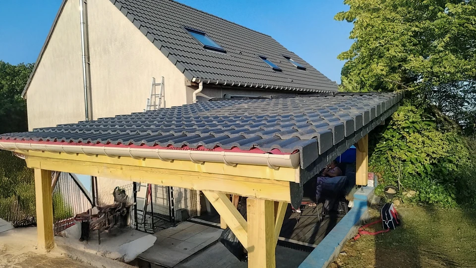 Vue ext&eacute;rieure d'une toiture en t&ocirc;le ondul&eacute;e galvanis&eacute;e avec chemin&eacute;es et &eacute;vents