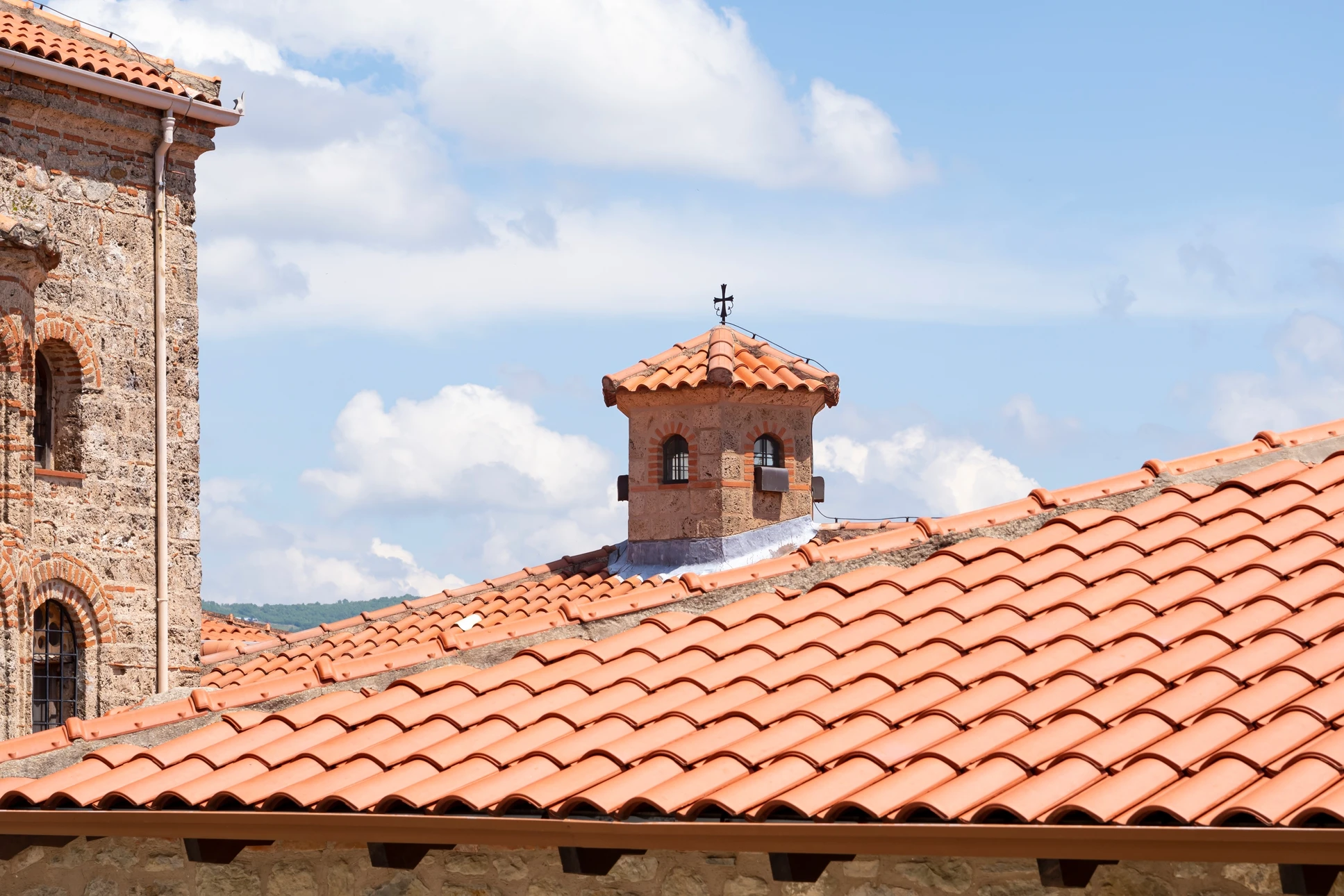 Une main utilise un chiffon jaune pour nettoyer une surface en bois montrant un contraste entre la zone poussiéreuse et la partie déjà nettoyée