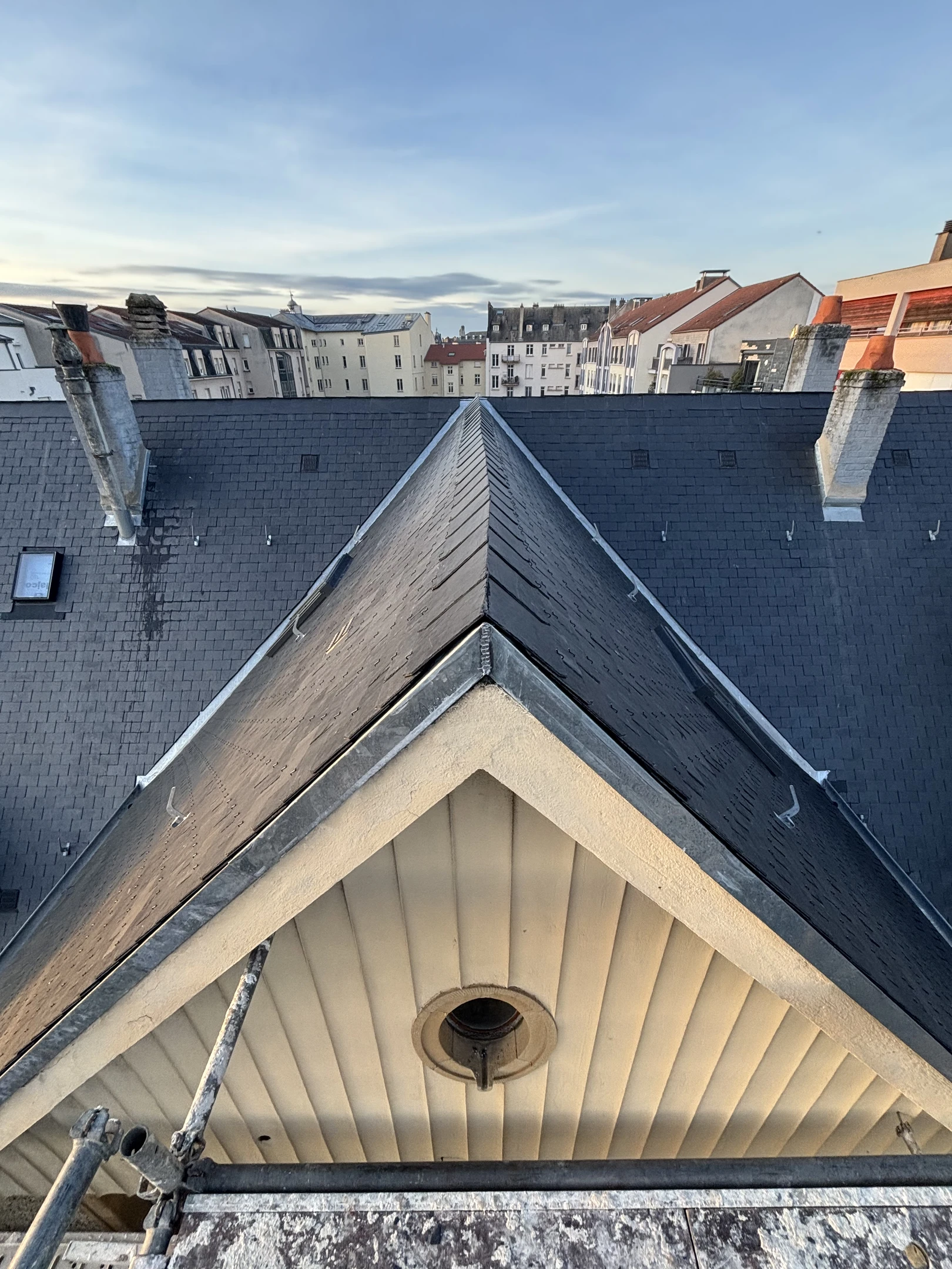 Sc&egrave;ne ext&eacute;rieure montrant une toiture en ardoise naturelle vue en contre-plong&eacute;e sous un ciel nuageux